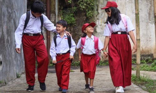 elementary-school-wear-uniform-backpack-talking-laughing-while-going-school_603656-3665