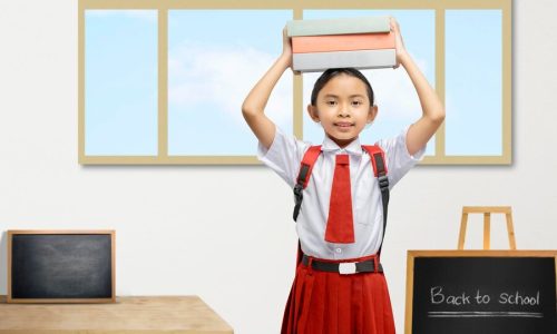 portrait-asian-elementary-school-student-girl-uniform-with-backpack-standing-while-carrying-stack-books_9083-24692